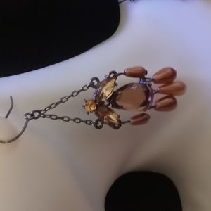 Dangling drop earrings. On black chains with Amber color Crystals and beads.